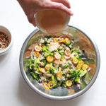 Verser la sauce sur la salade brocoli, kumquat & amandes