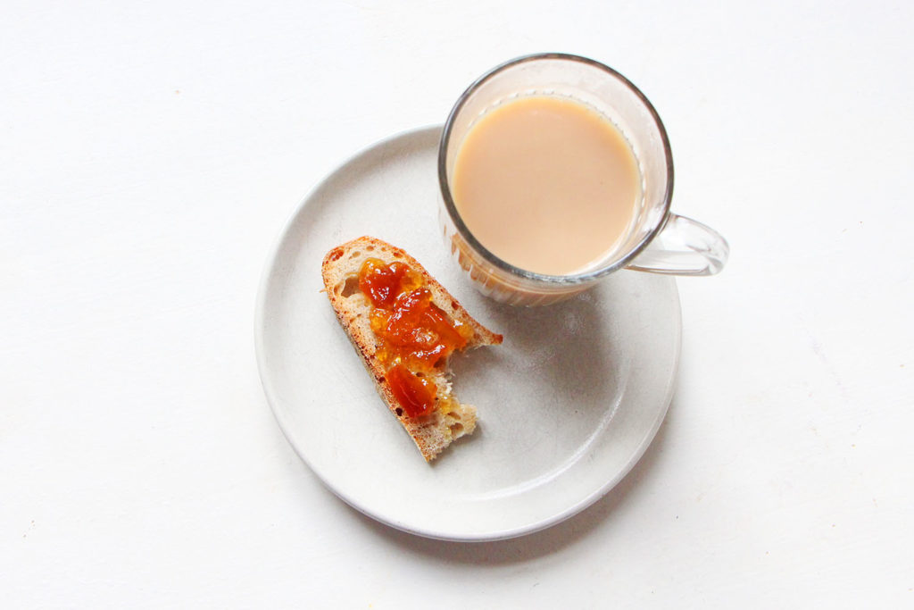 Tartine de marmelade d'orange et mug de thé au lait